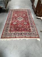 TAPIS laine à décor géométrique sur fond rouge. 280 x...