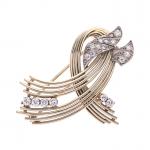 BROCHE "Volute" en or gris 750/°° sertie de diamants demi-taille...