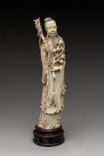 STATUETTE en ivoire. Philosophe tenant une branche de pommier et...