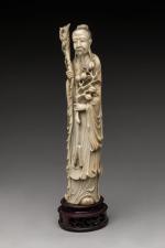 STATUETTE en ivoire. Philosophe tenant une branche de pommier et...