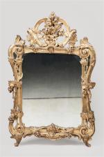 MIROIR en bois sculpté et doré à décor au fronton...