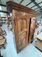 Une ARMOIRE en noyer et incrustations de bois ouvrant par...