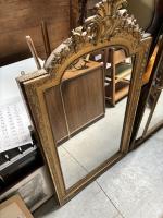 Un MIROIR en bois doré et stuqué à décor d'une...