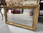 MIROIR en bois doré à décor de médaillons aux écoinçons...