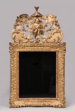 * MIROIR en bois sculpté et doré, à décor de...