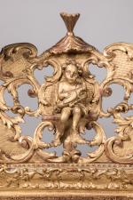 * MIROIR en bois sculpté et doré, à décor de...