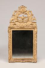 MIROIR en bois sculpté et partiellement redoré, à décor de...