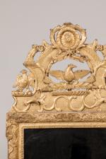 MIROIR en bois sculpté et partiellement redoré, à décor de...