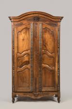 ARMOIRE en noyer mouluré sculpté, ouvrant à deux portes à...