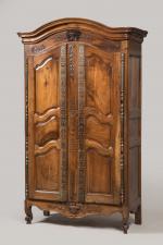 ARMOIRE en noyer mouluré sculpté, ouvrant à deux portes à...