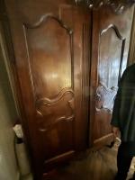 Une ARMOIRE en noyer mouluré et sculpté d'un panier fleuri,...